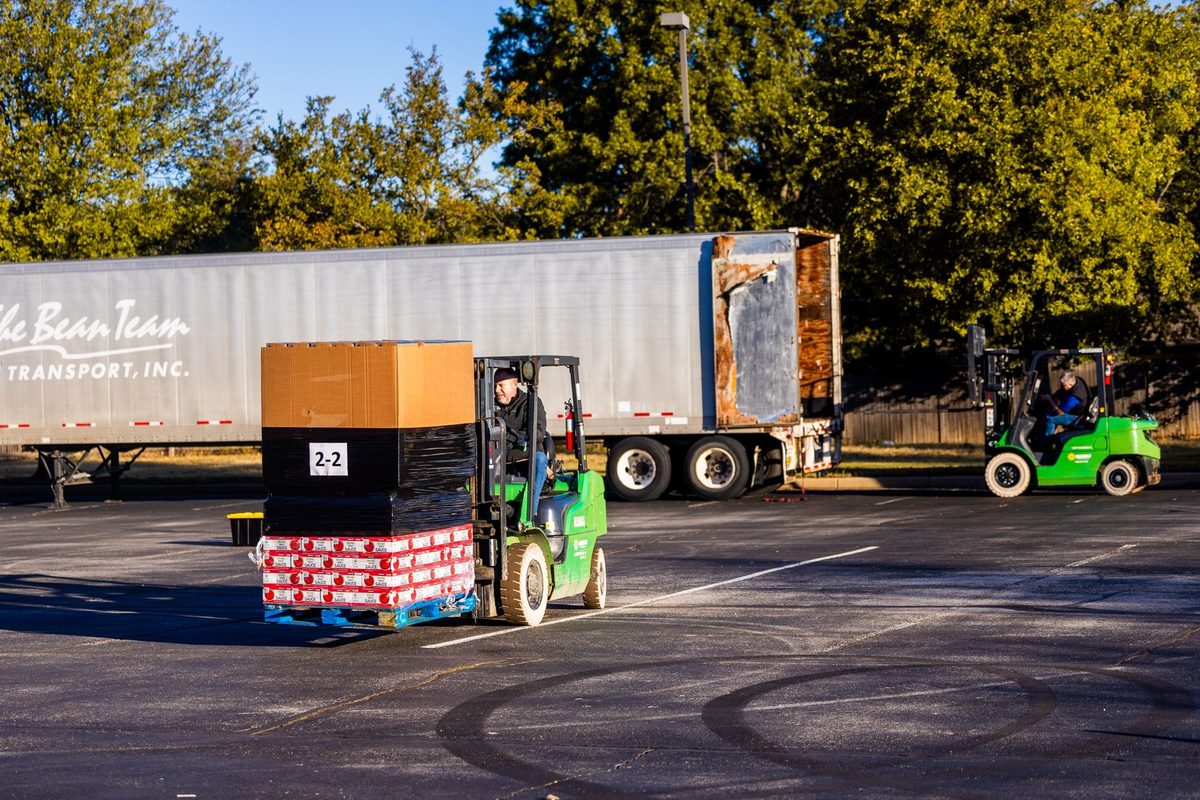 Magazijnmedewerkers laden met een heftruck pallets in een vrachtwagen