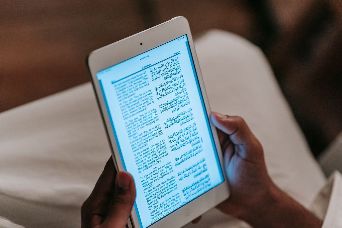 Een persoon leest rustig een artikel op een tablet