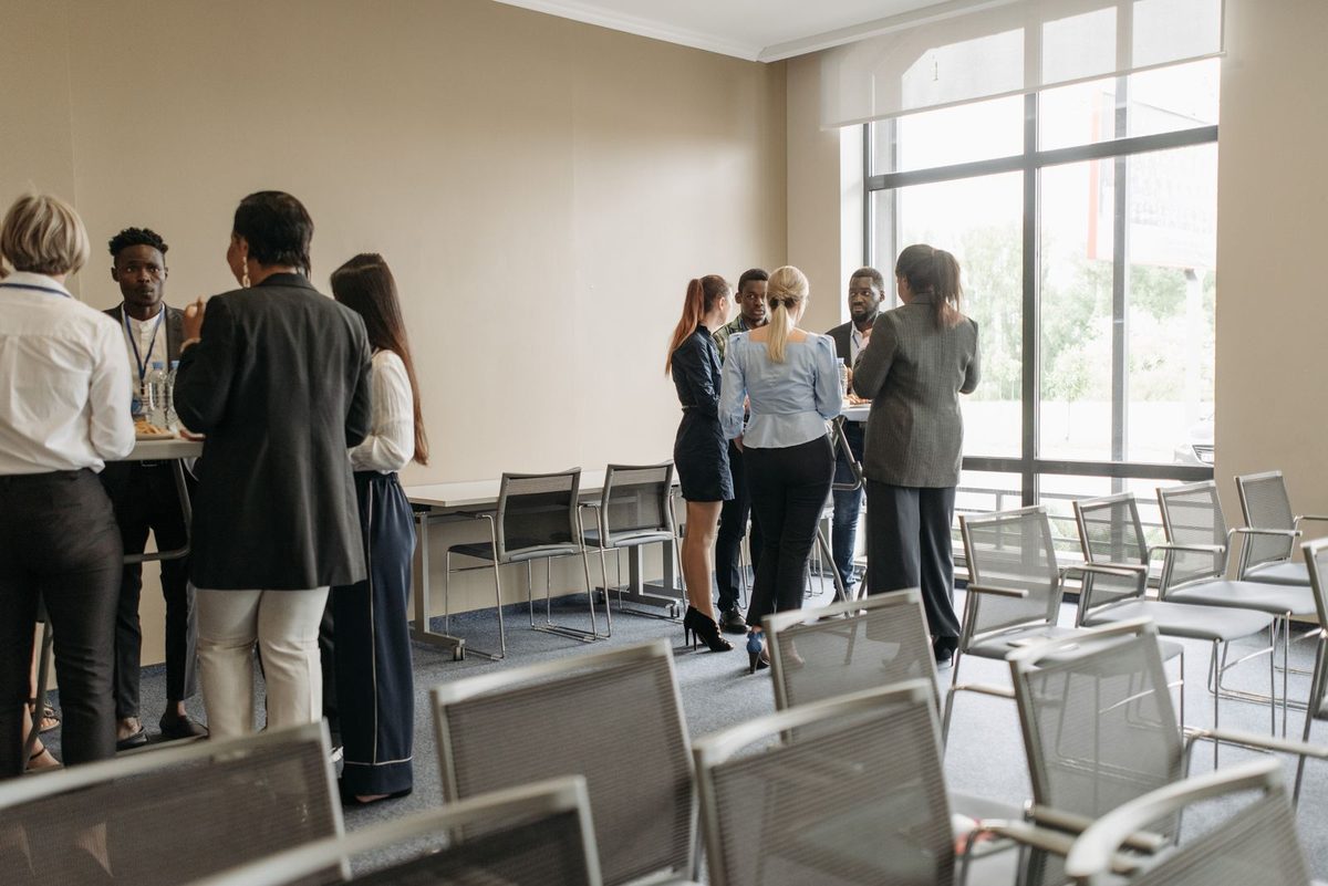 Een groep professionals praat informeel met elkaar op kantoor