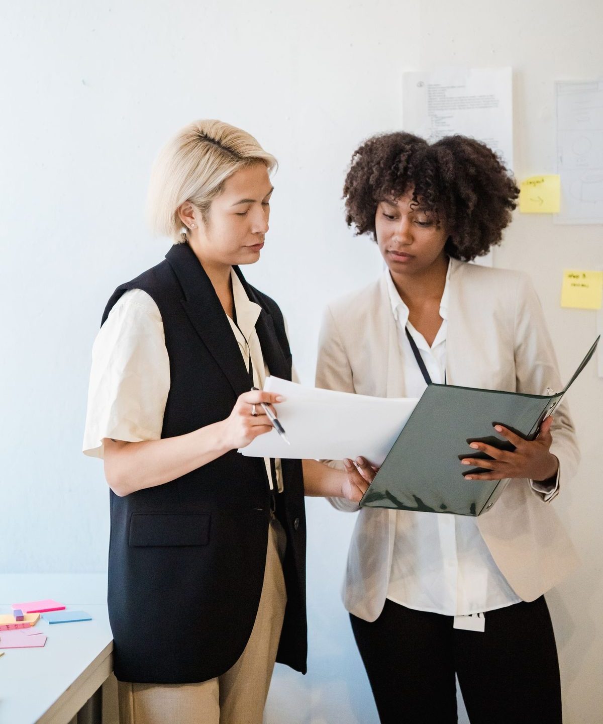 Twee professionals bekijken samen een document in warm licht